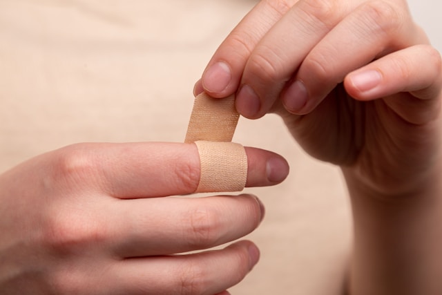 A picture of a person wrapping a band-it on the right pointer finger